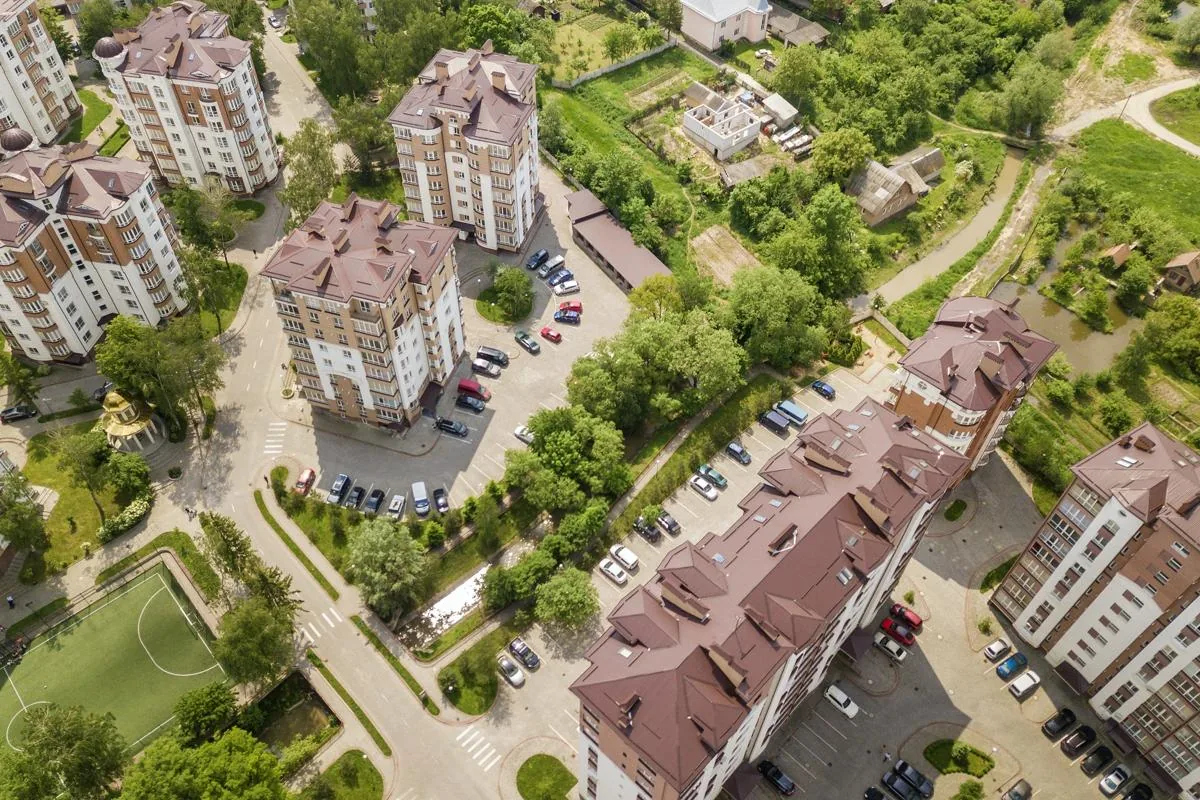Top view of apartment or office tall buildings, parked cars, urban city landscape. Drone aerial
