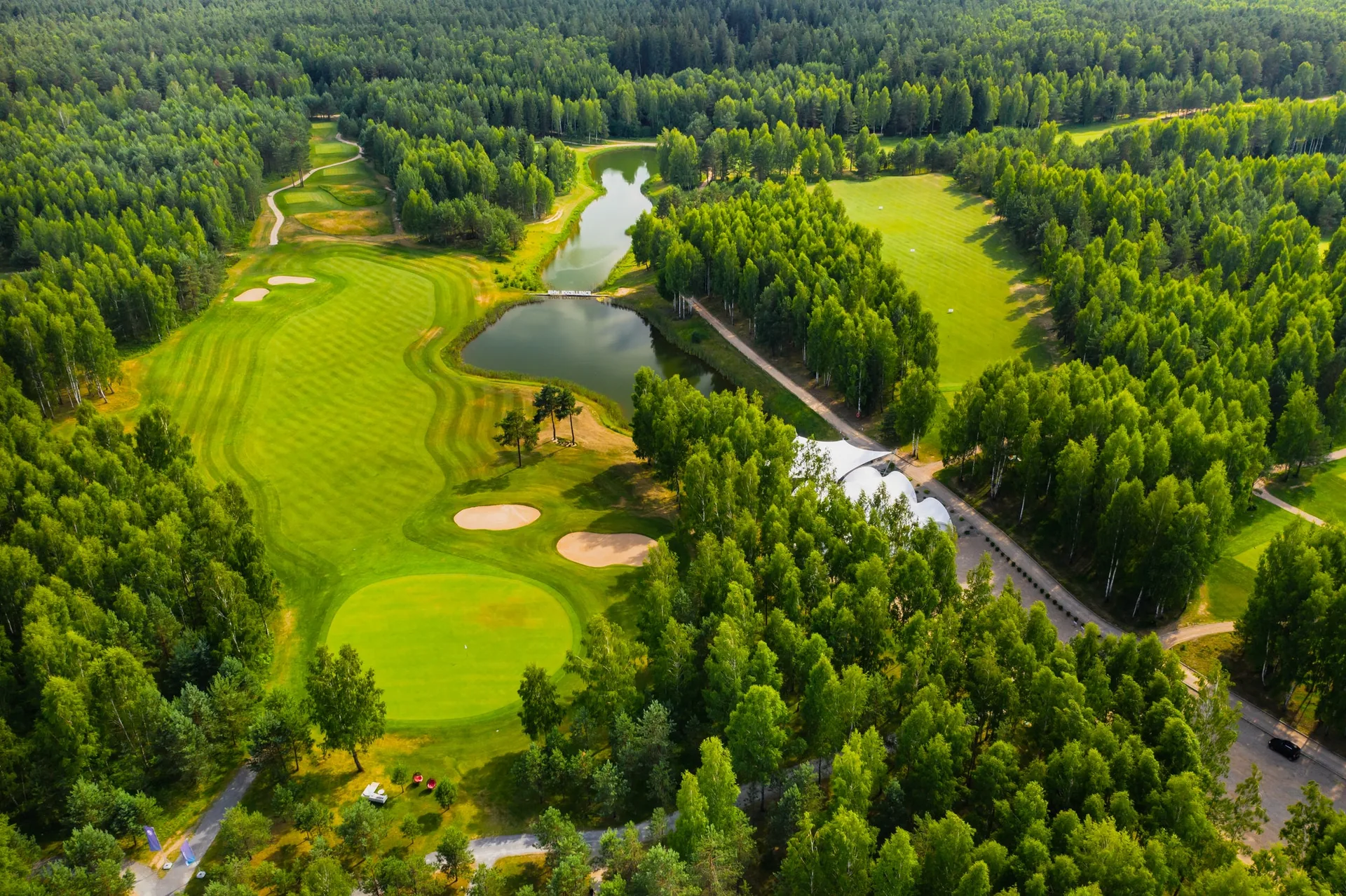 Top view of the golf course located in a wooded area